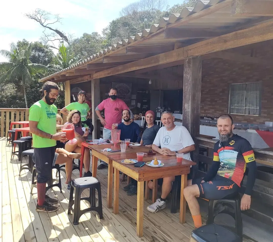 Ciclistas reunidos à mesa durante uma parada do roteiro rural