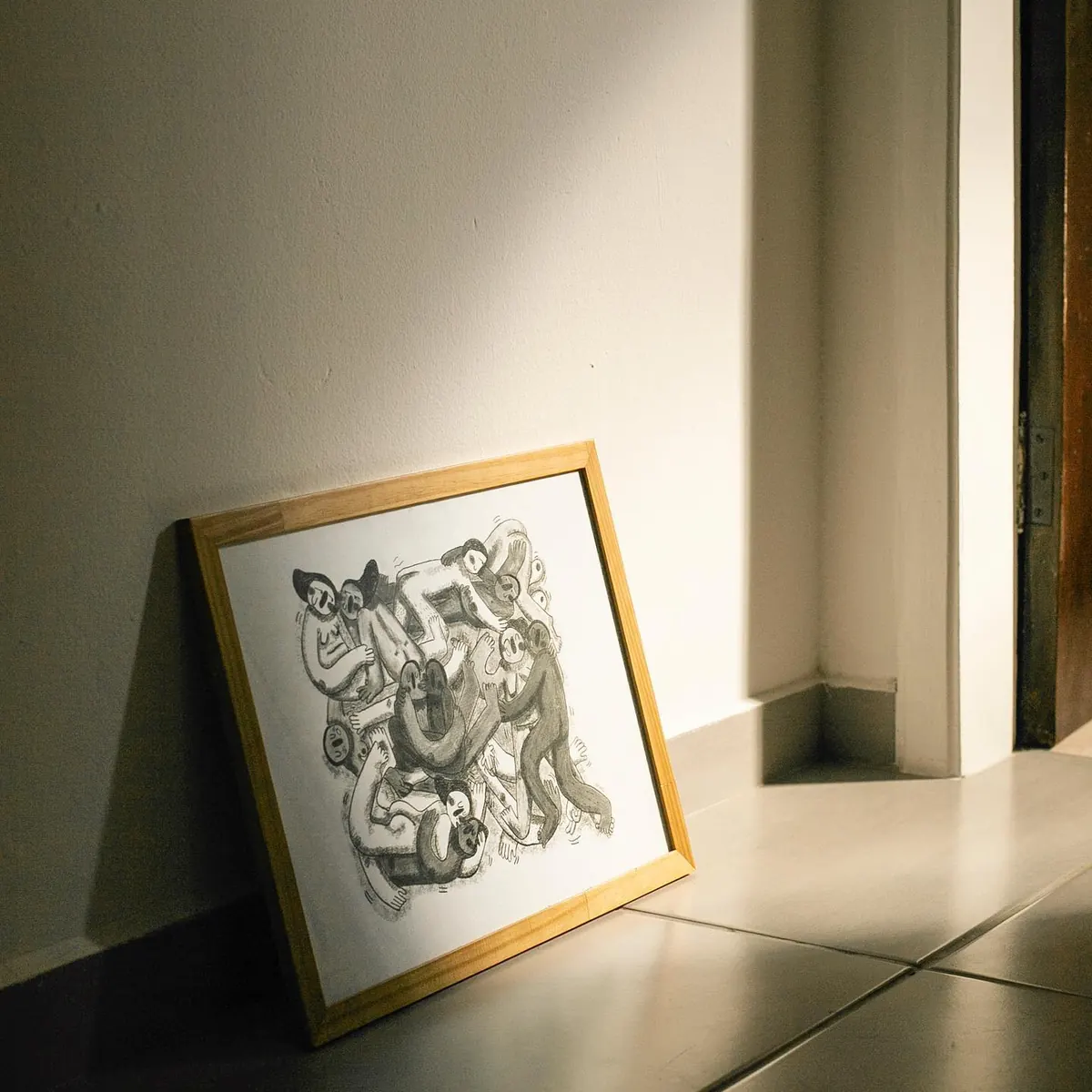 Quadro apoiado no chão recebendo luz de janela no apartamento 403