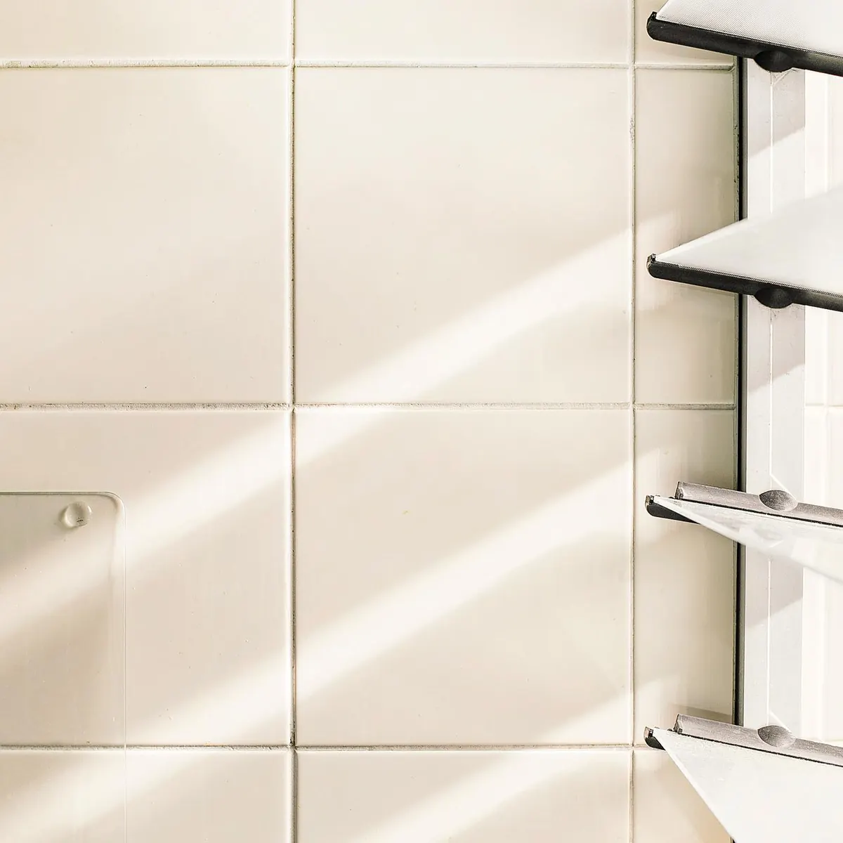 Parede de azulejo branco e prateleira metálica no apartamento 403