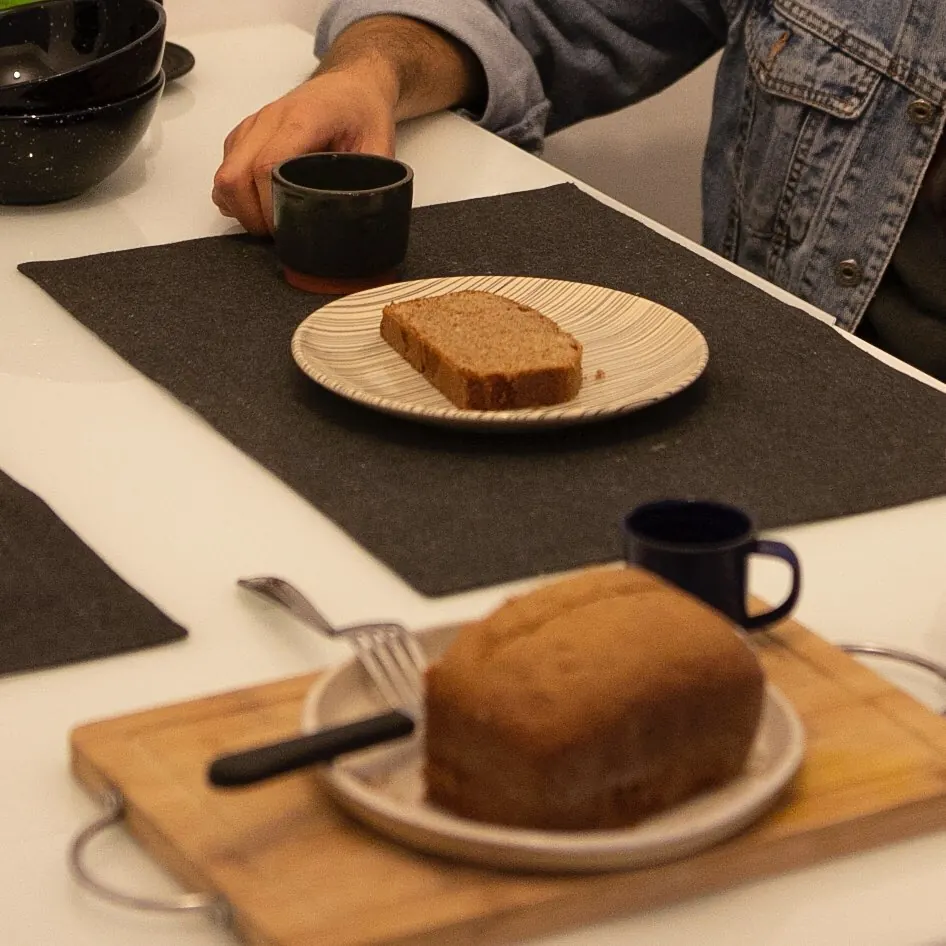 Café e bolo servidos sobre bancada no apartamento 403