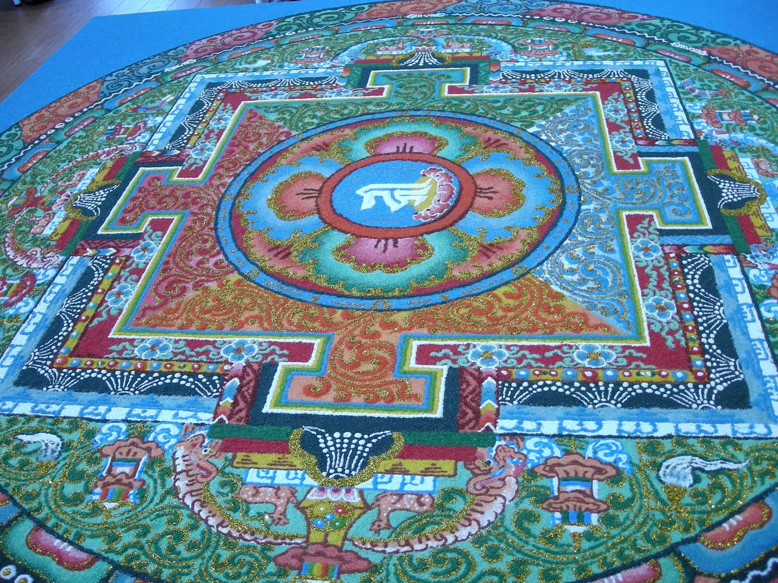 Mandala de areia tibetana quase concluída, com padrões geométricos coloridos de extrema precisão criados por lamas budistas ao longo de vários dias