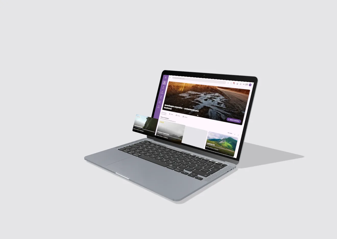 Notebook em ângulo três quartos com uma tela de aprendizagem roxa; dois cards de trilha, com título e selo, saem da tela e flutuam à frente do teclado.